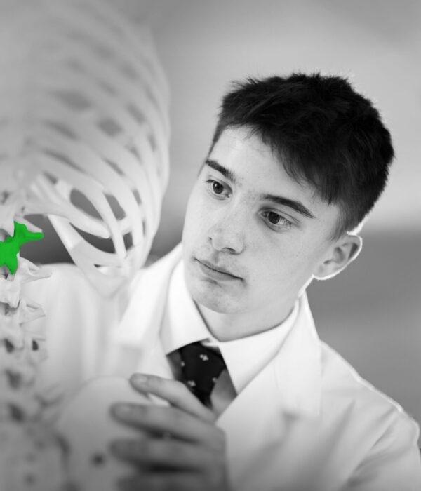 student looking at a green piece of bone