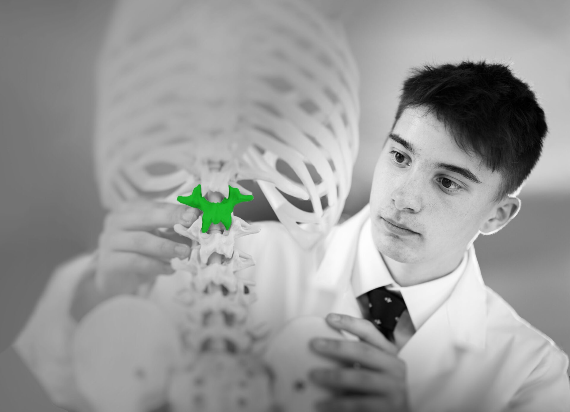 student looking at a green piece of bone