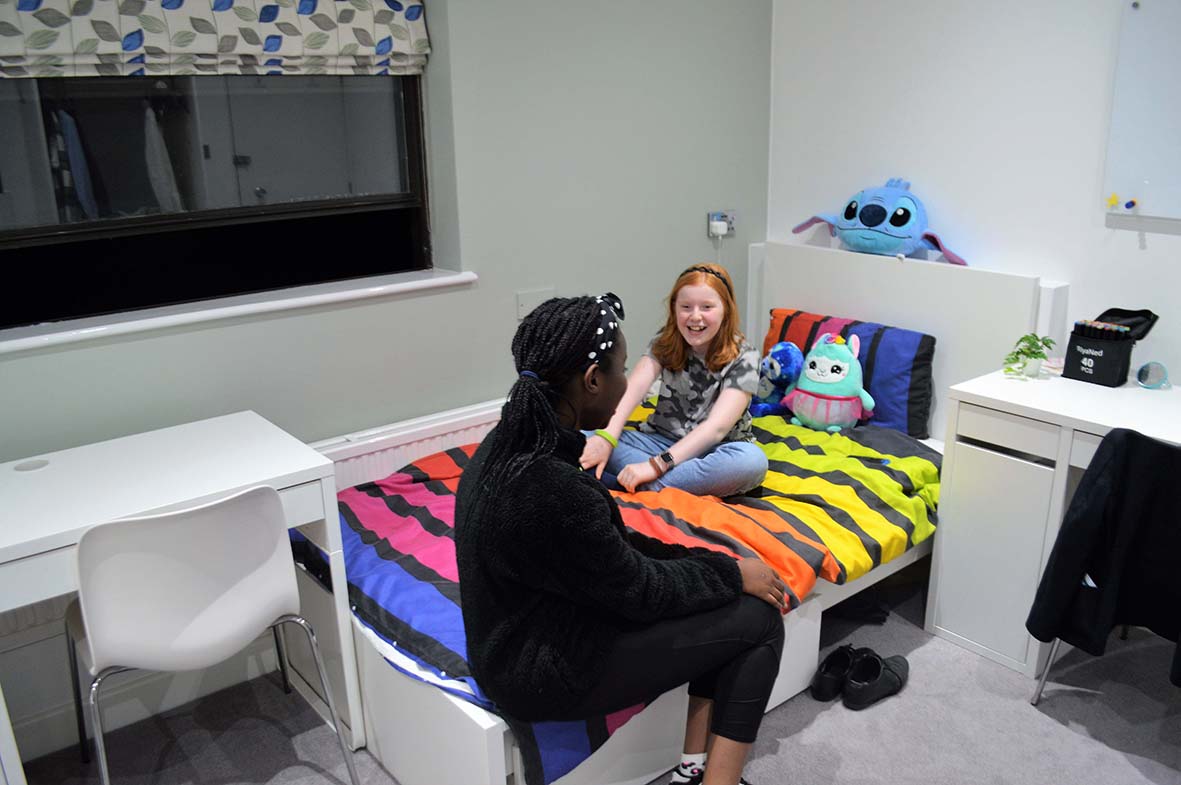 students sitting on a bed