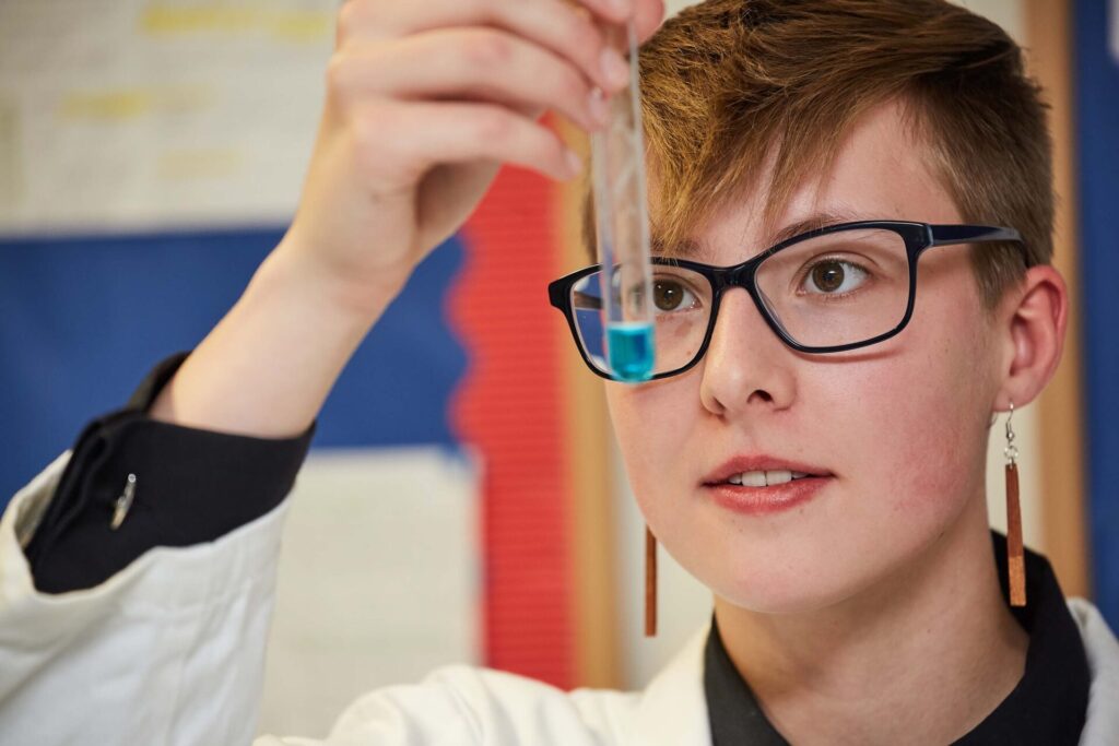 student looking at a test tube
