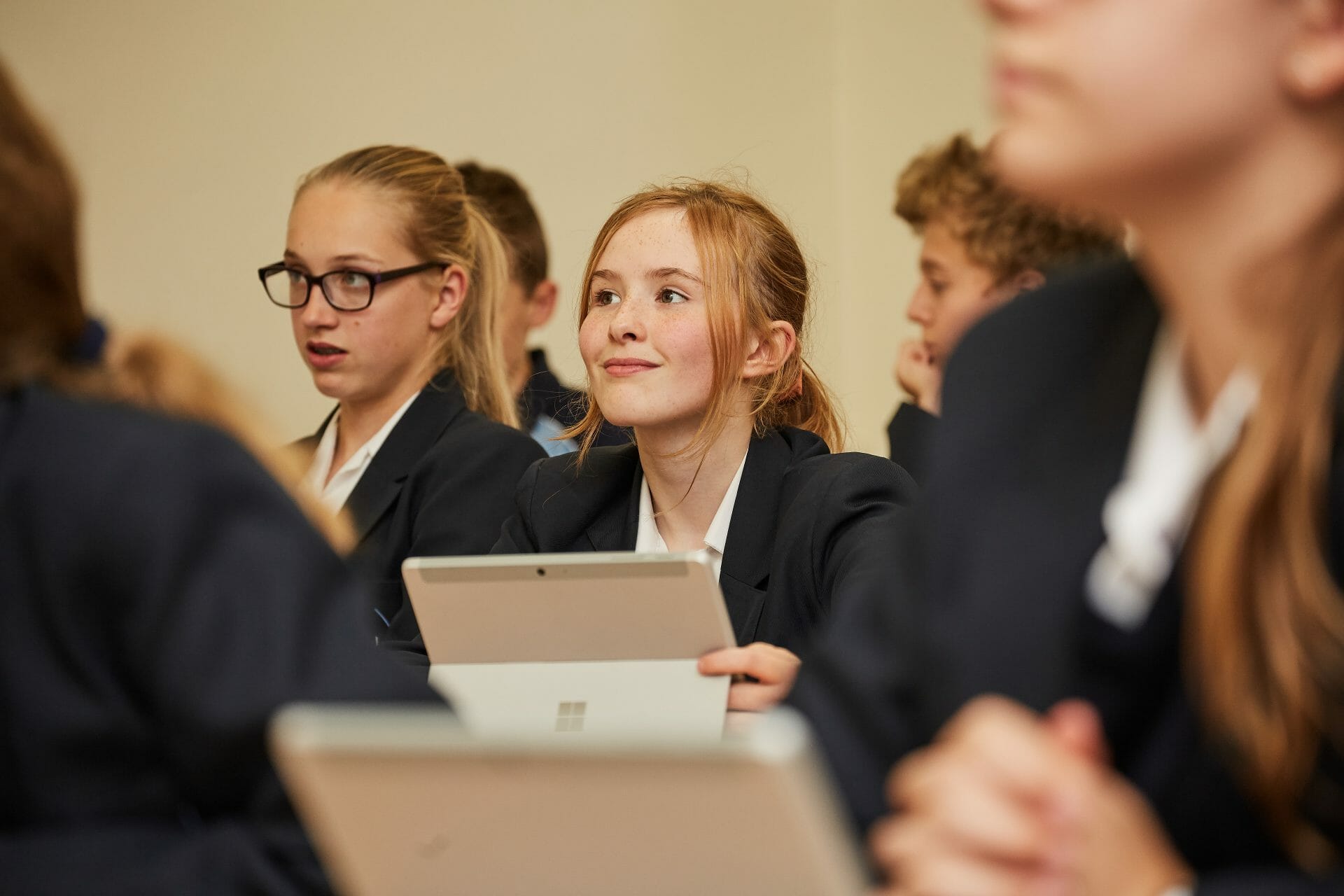 student in a crowd holding a tablet