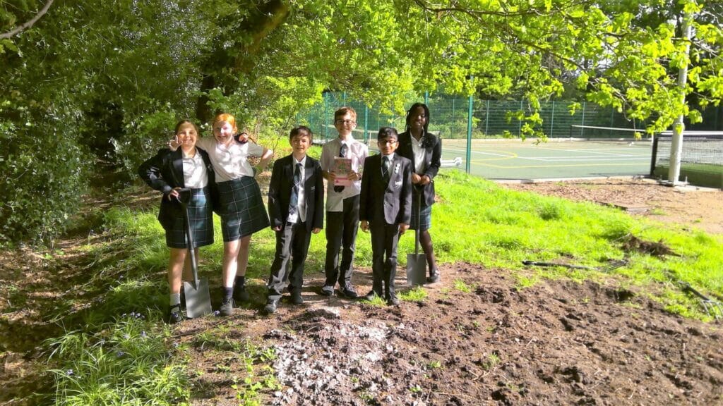 children stand on freshly dug soil