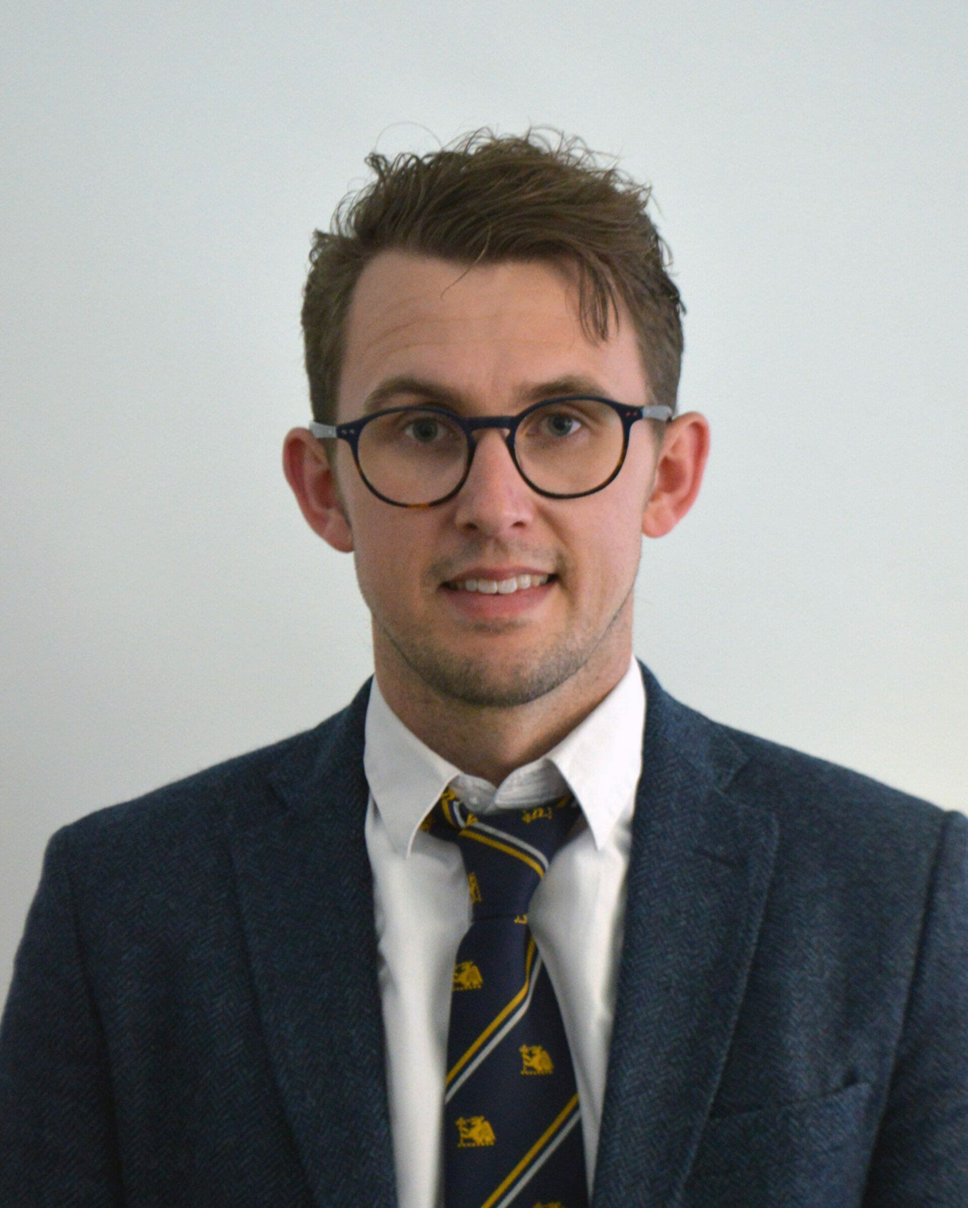 man wearing glasses and a suit