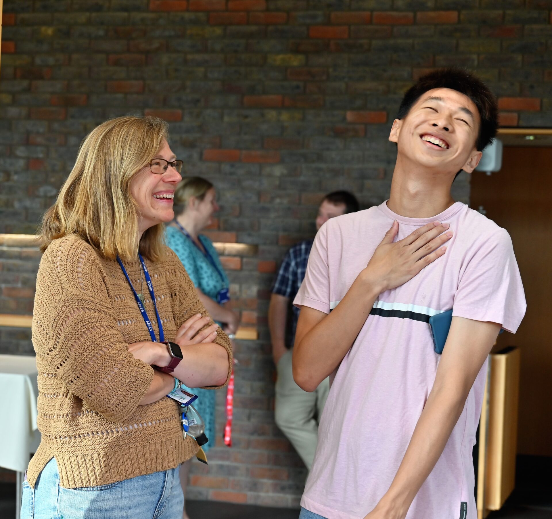 student laughing as a teacher smiles